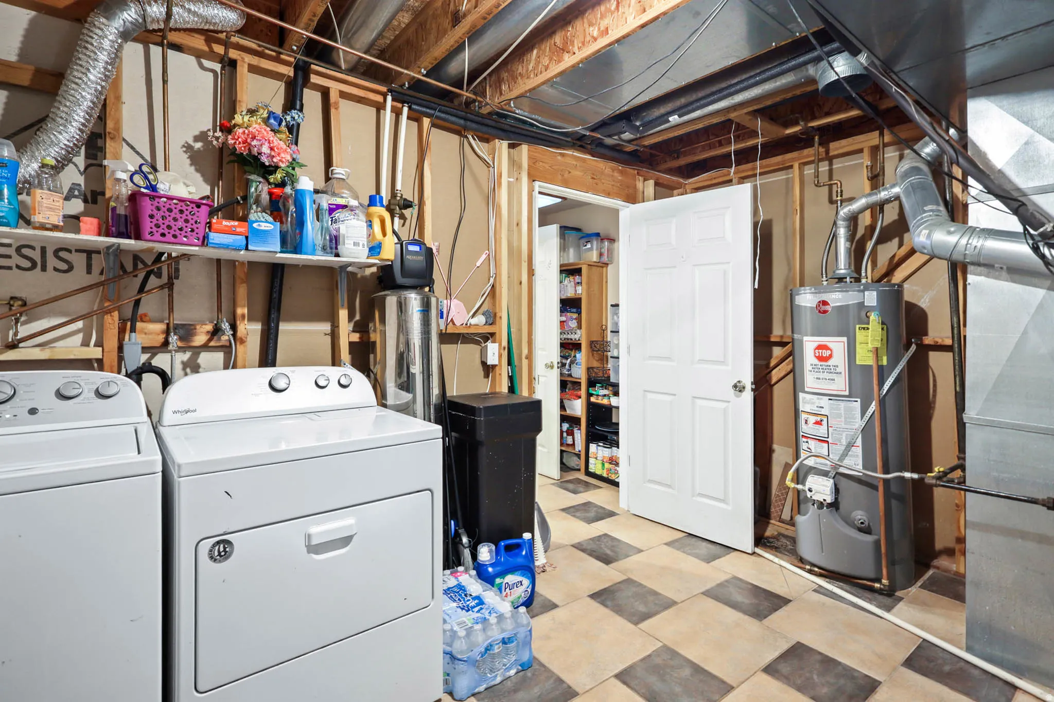 Laundry area featuring tile patterned floors, water heater, heating unit, and washing machine and clothes dryer