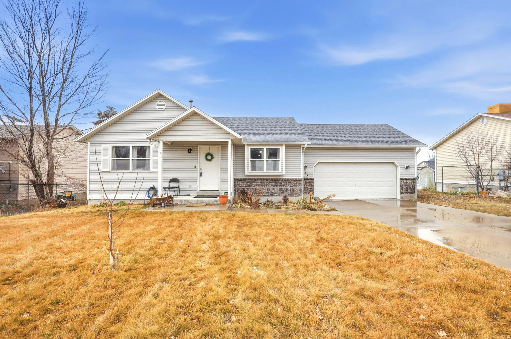View of front of property featuring concrete driveway, an attached garage, a front lawn, and roof with shingles