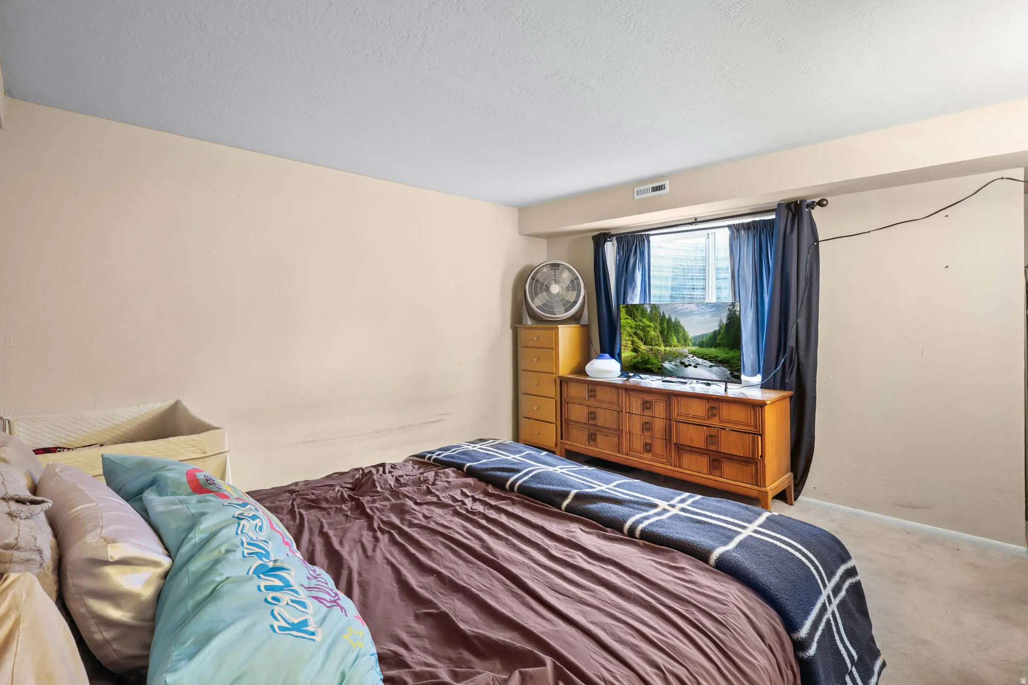 Bedroom with carpet and a textured ceiling