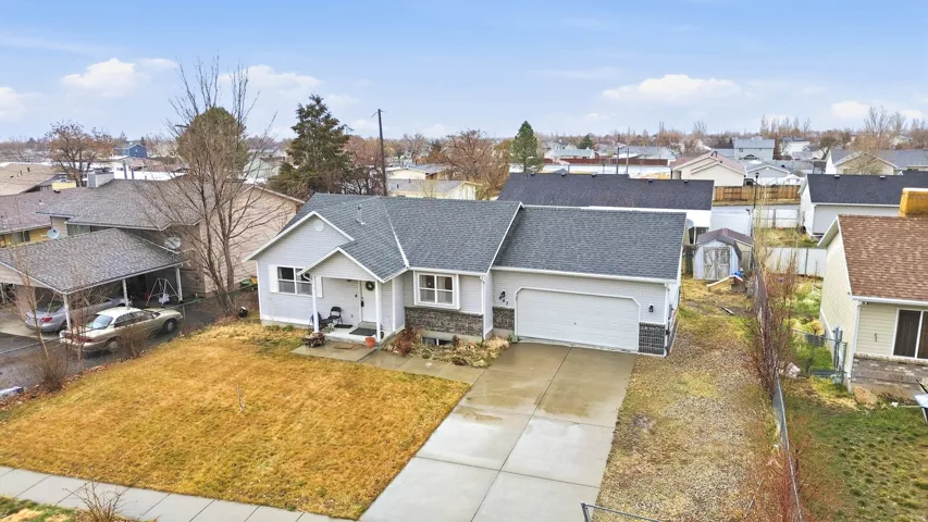 View of front of house with a garage, driveway, a residential view, and a shingled roof