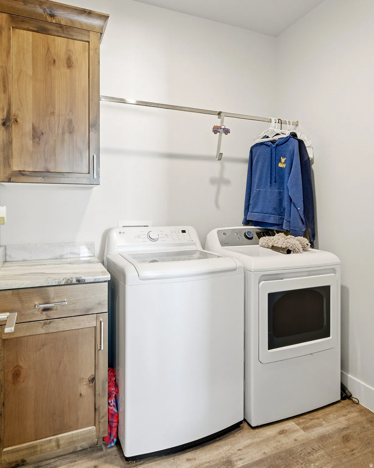 Laundry room featuring light wood-style floors, washing machine and dryer, and cabinet space