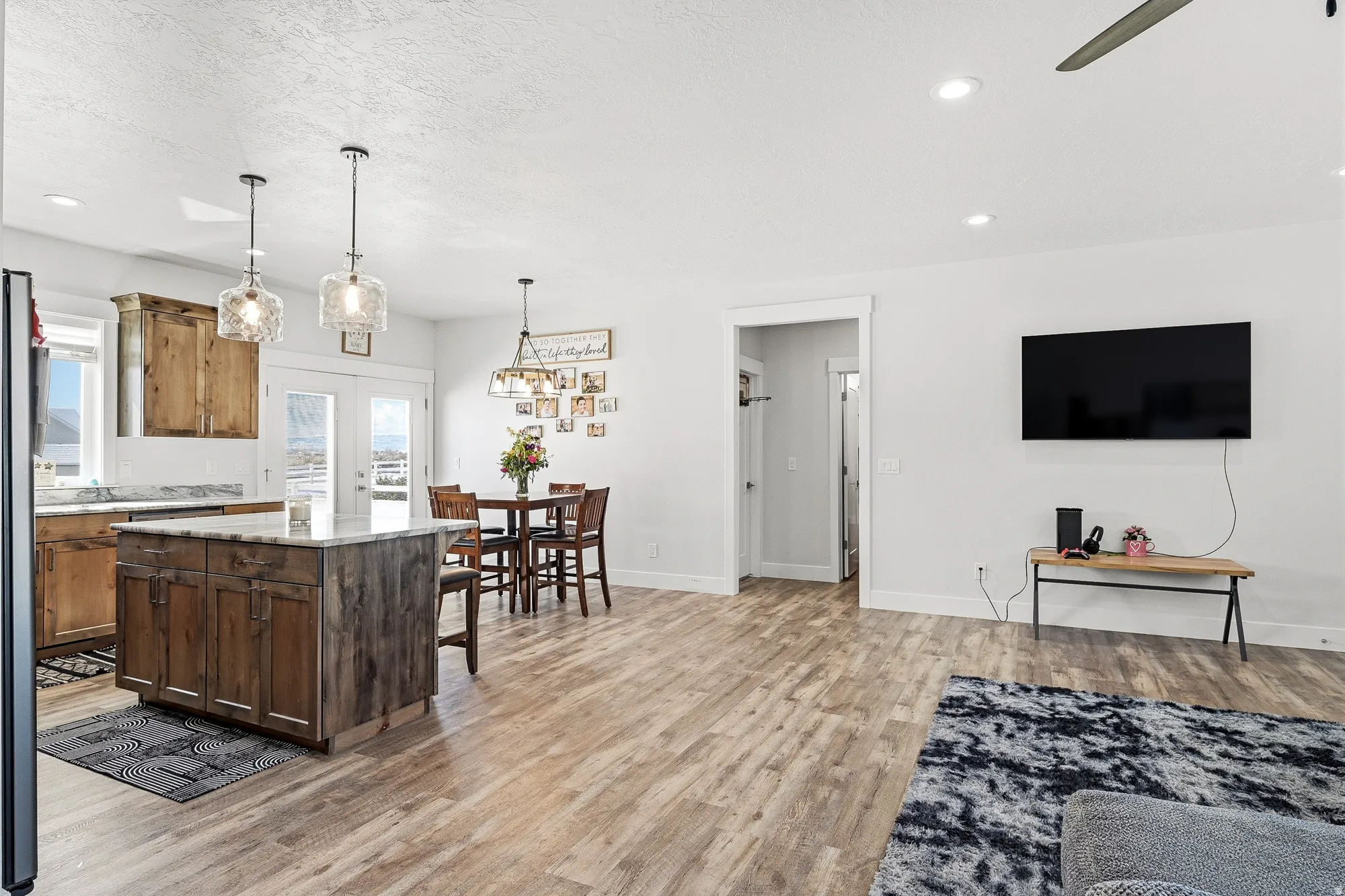 Kitchen with pendant lighting, light stone countertops, a center island, light wood finished floors, and a breakfast bar