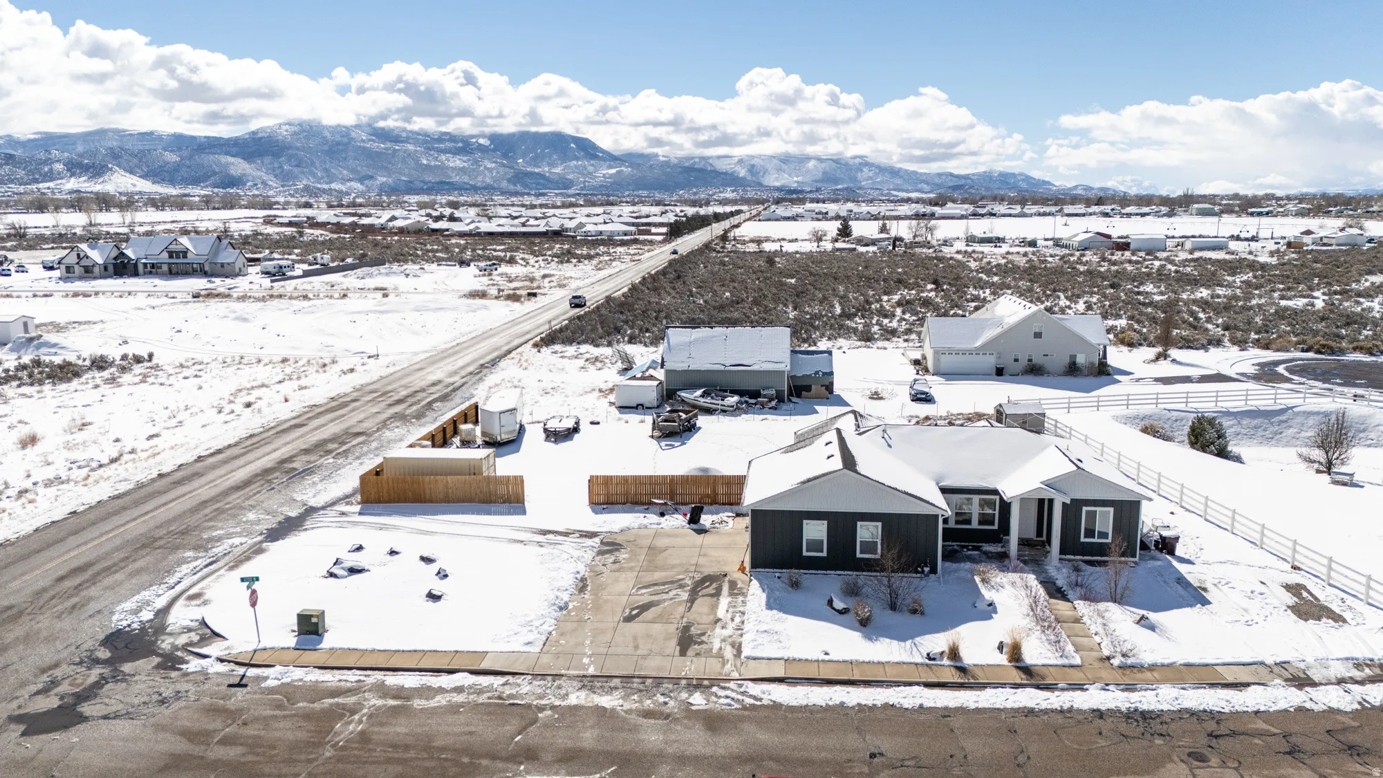 Snowy aerial view featuring a mountain view and a residential view
