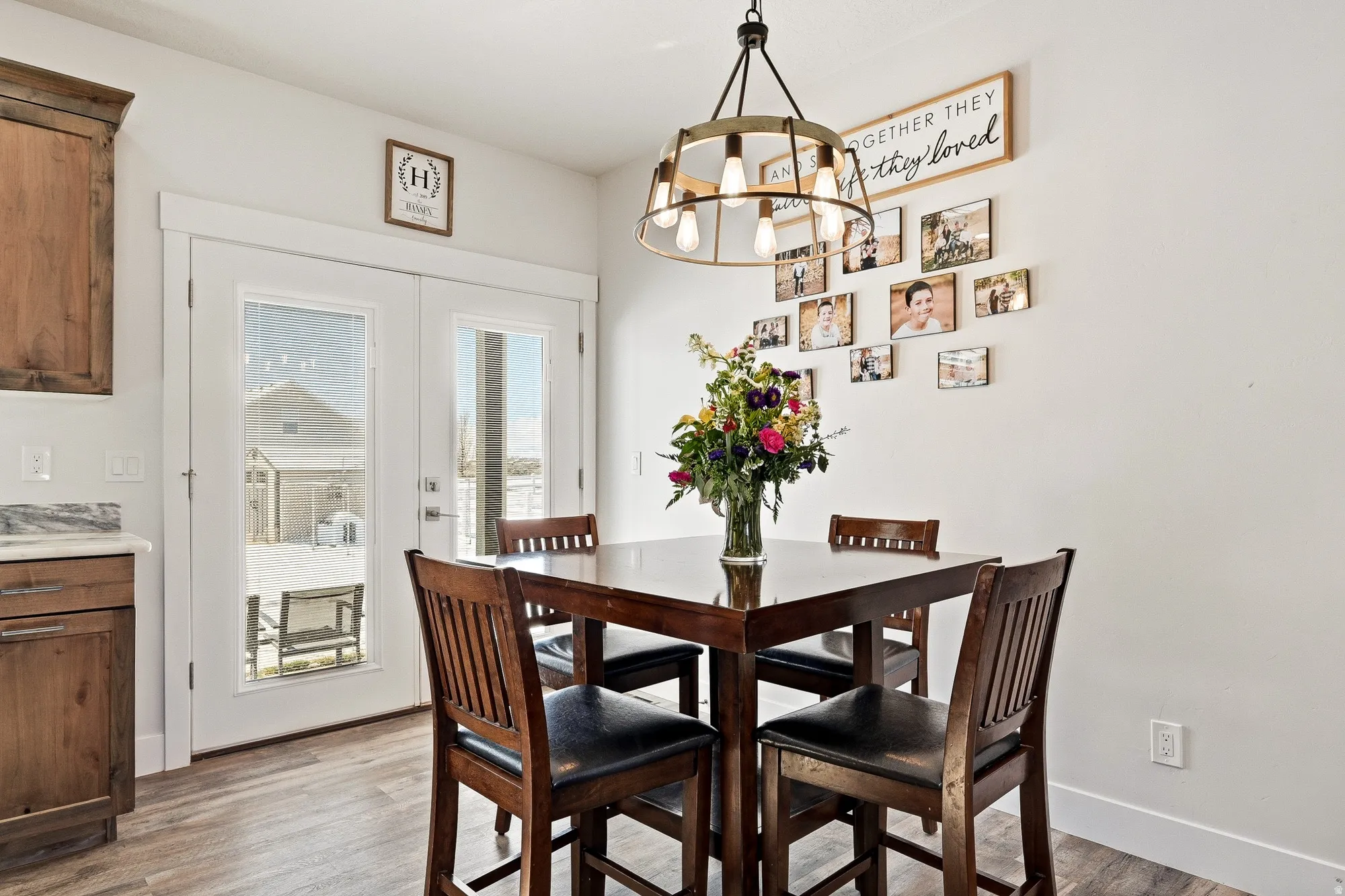 Dining room featuring light wood finished floors, suspended lighting, and french doors