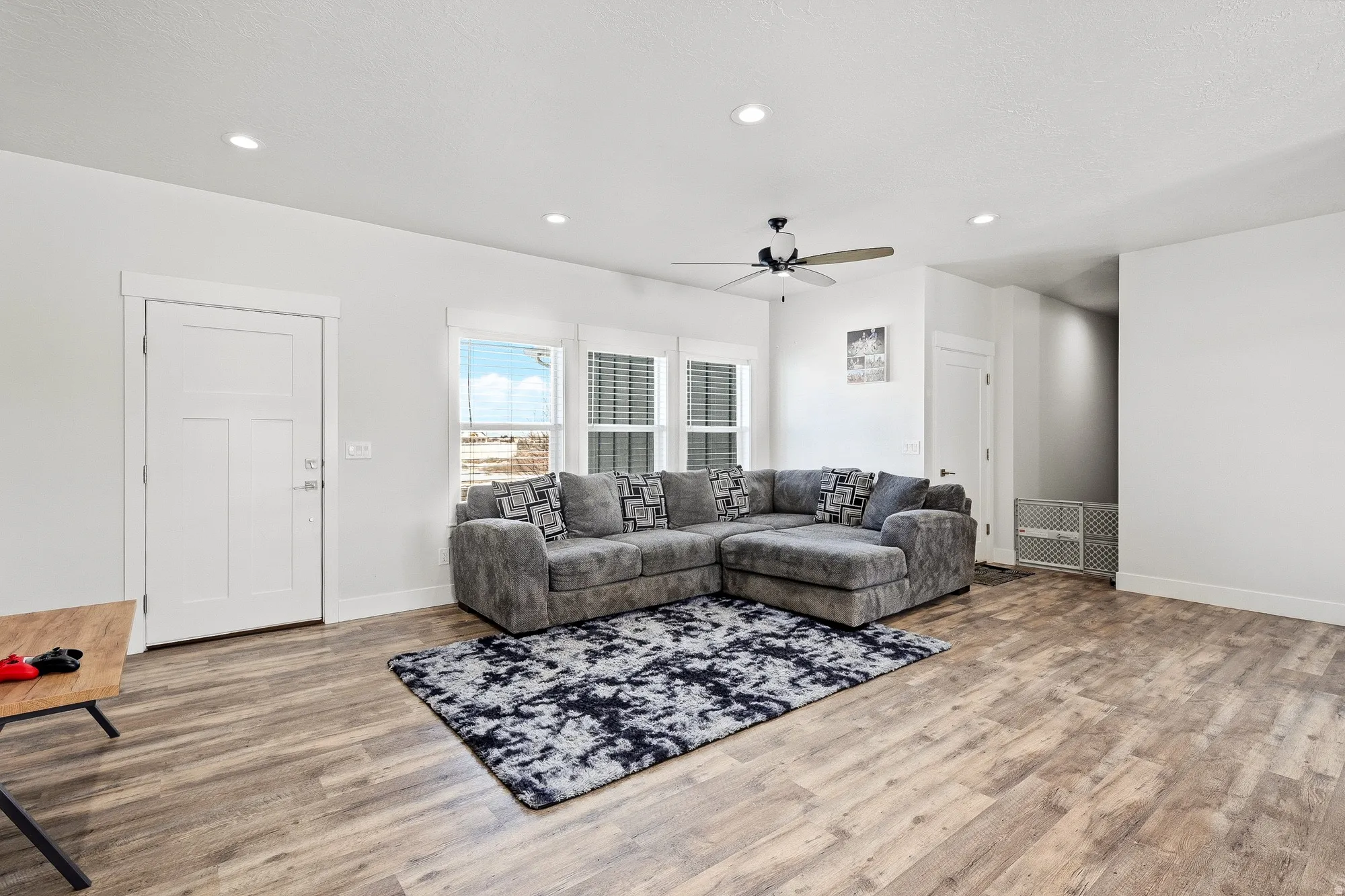 Living room with light wood finished floors, a ceiling fan, and recessed lighting