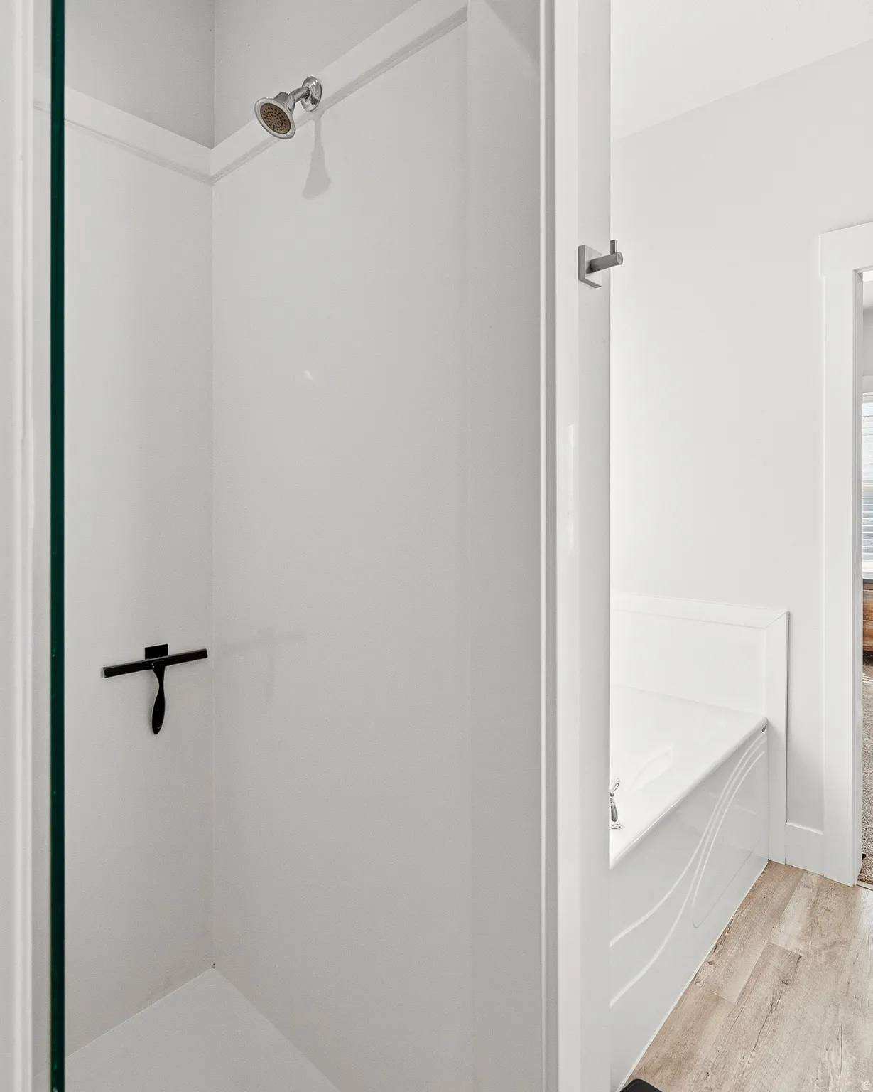 Bathroom with a bath, wood finished floors, and a shower stall