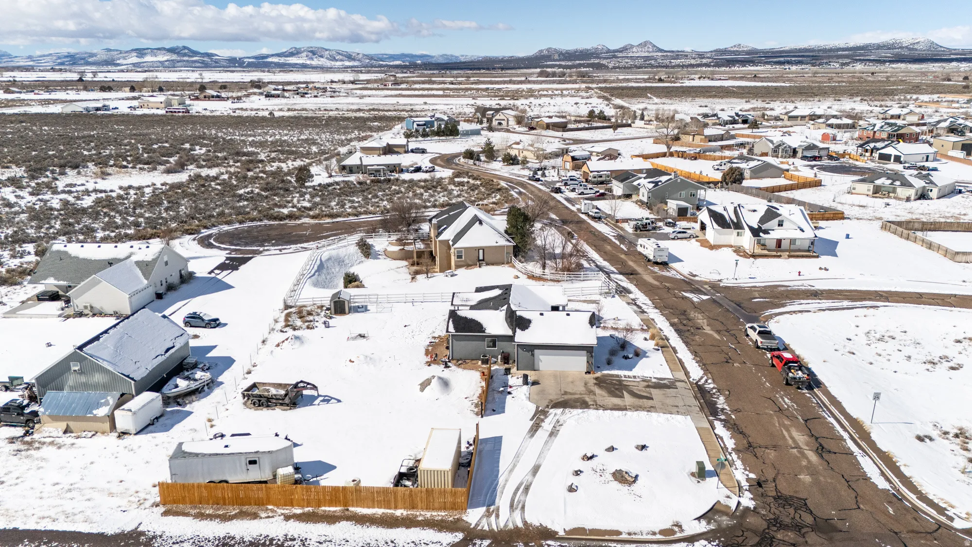 Snowy aerial view featuring a mountain view and a residential view