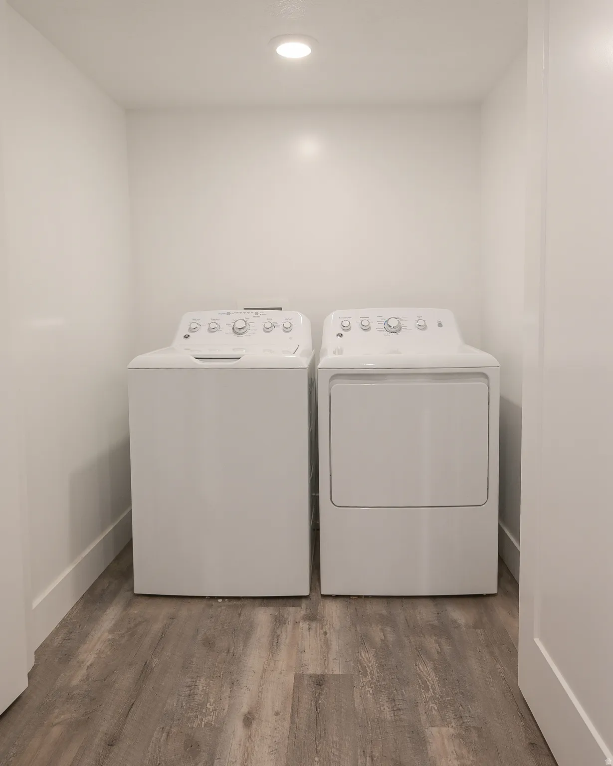 Laundry area with wood finished floors, separate washer and dryer, and recessed lighting