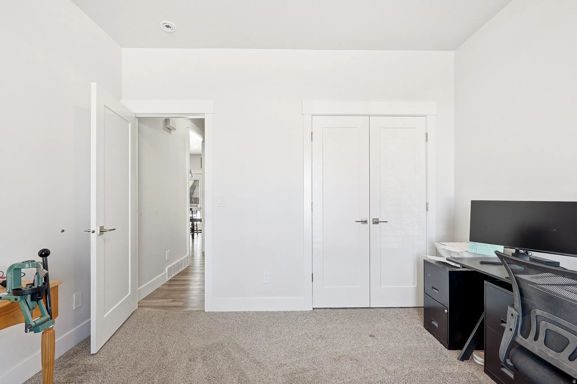 Office space with light carpet and baseboards