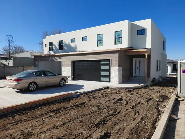 Contemporary home with concrete driveway, stucco siding, and an attached garage
