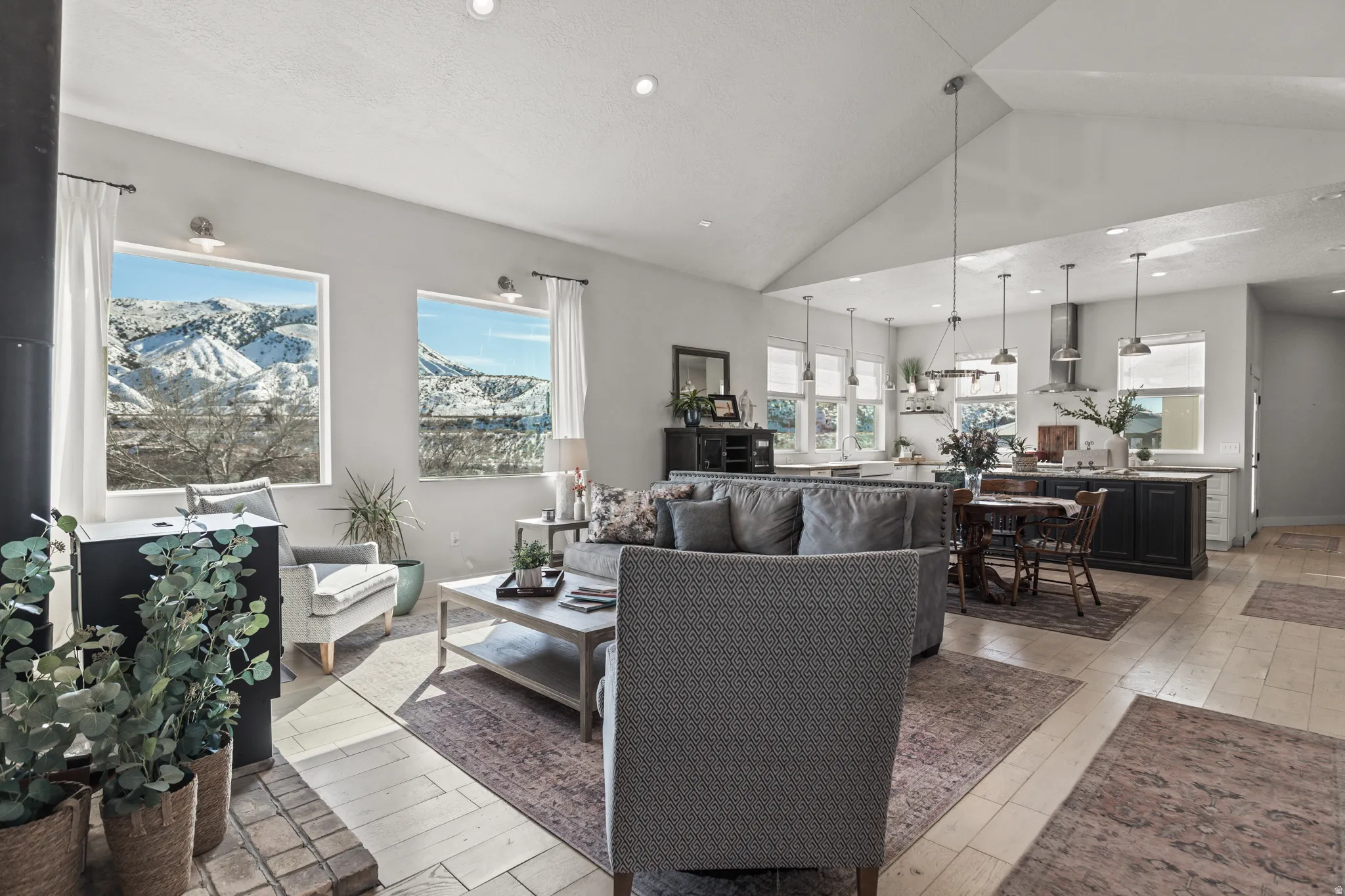 Living room with light wood finished floors, a mountain view, recessed lighting, and a high ceiling