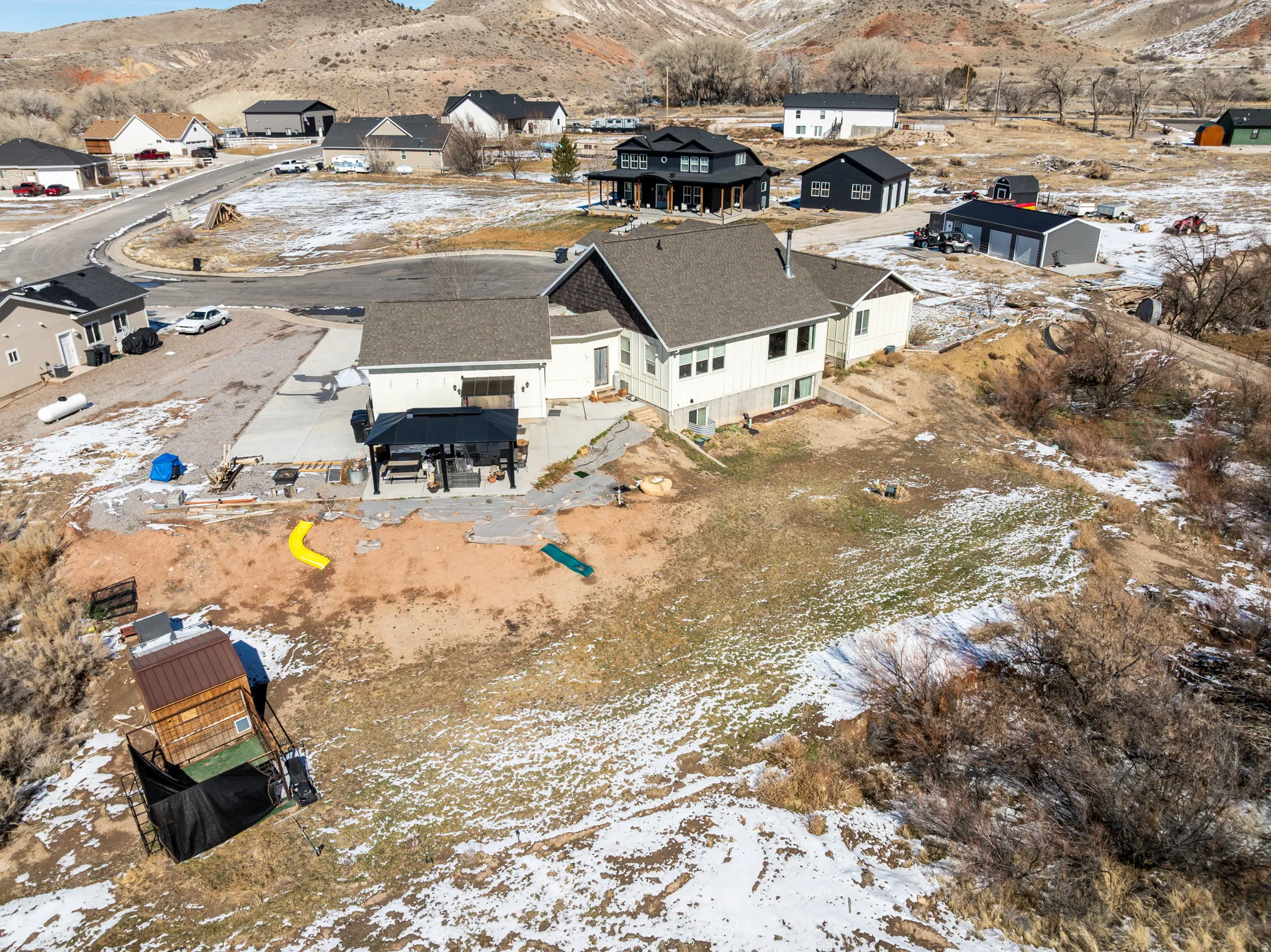 Snowy aerial view featuring a mountain view and a residential view