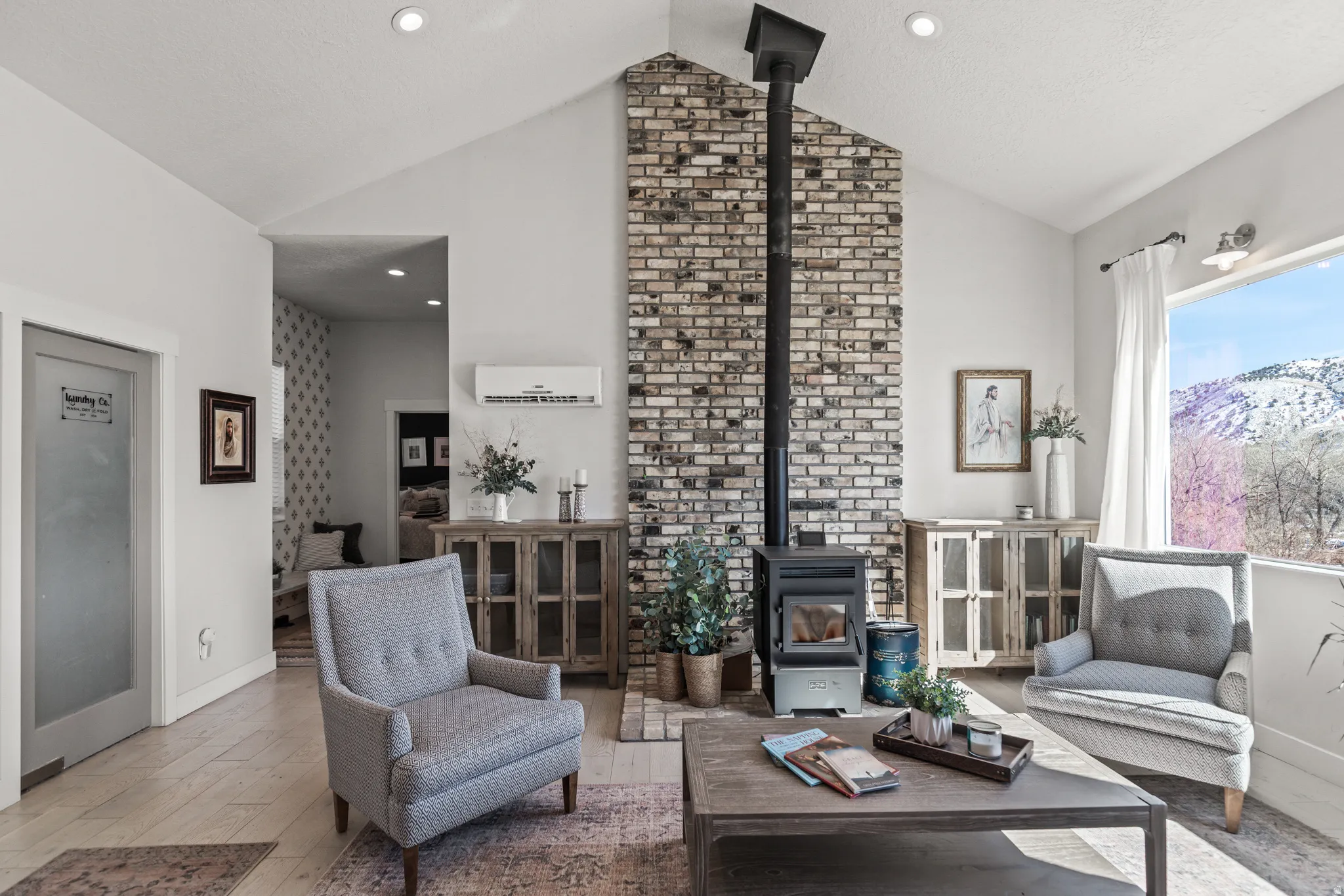 Living area with a wood stove, hardwood / wood-style flooring, a mountain view, recessed lighting, and a high textured ceiling