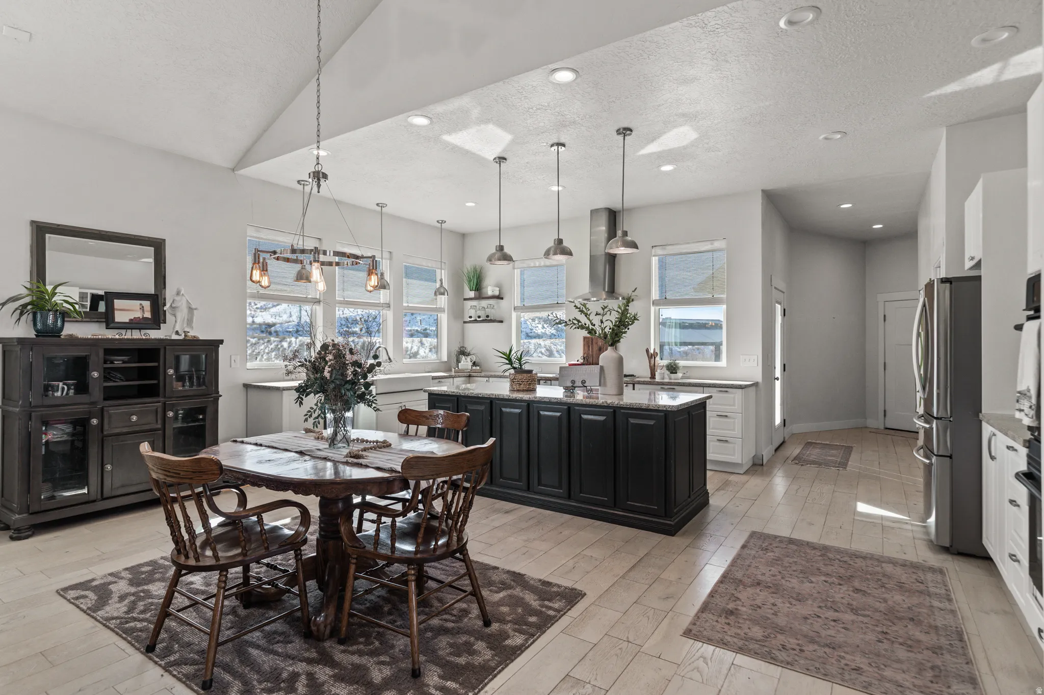 Dining room with a textured ceiling, light wood-style floors, and recessed lighting