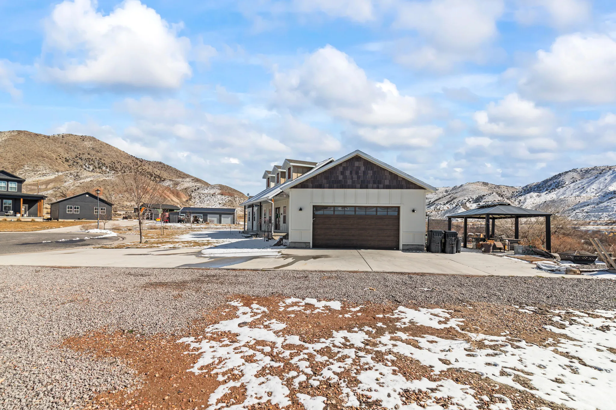 View of front facade with a mountain view, concrete driveway, a garage, and a gazebo