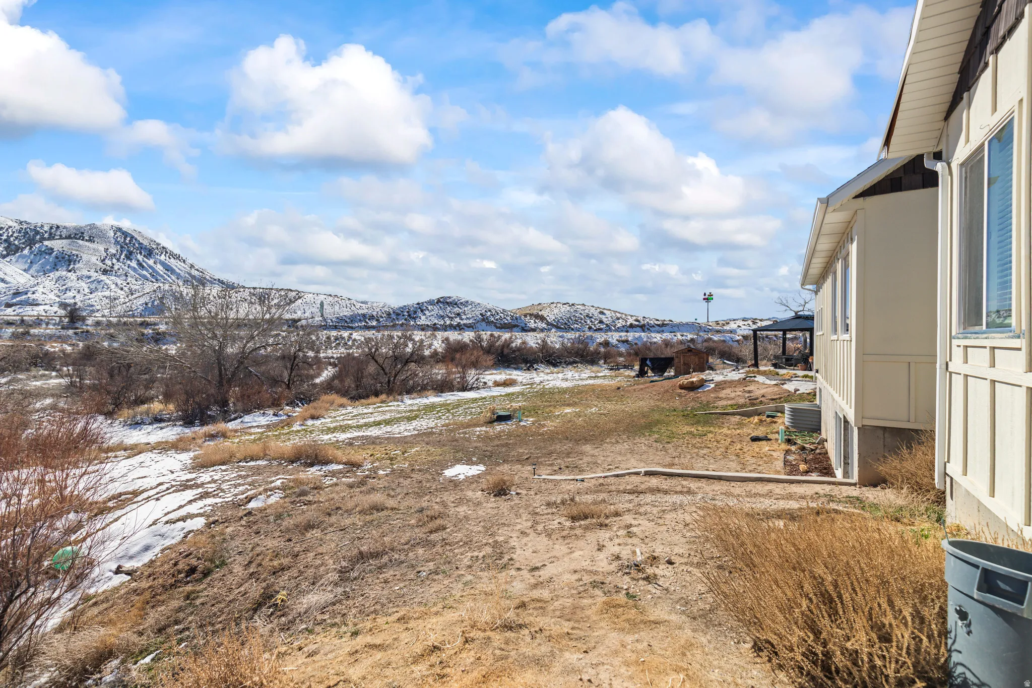 Yard covered in snow featuring a mountain view