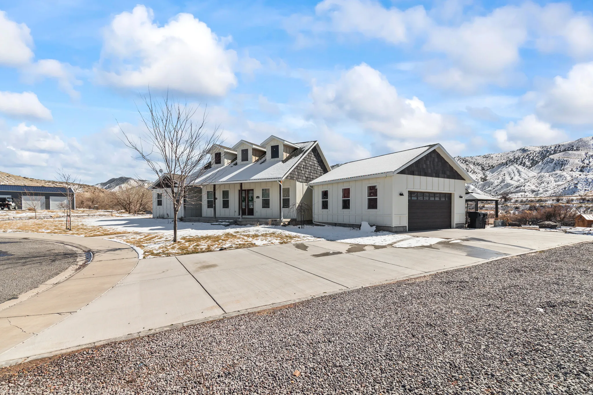 View of front facade featuring a porch, board and batten siding, a mountain view, driveway, and a garage