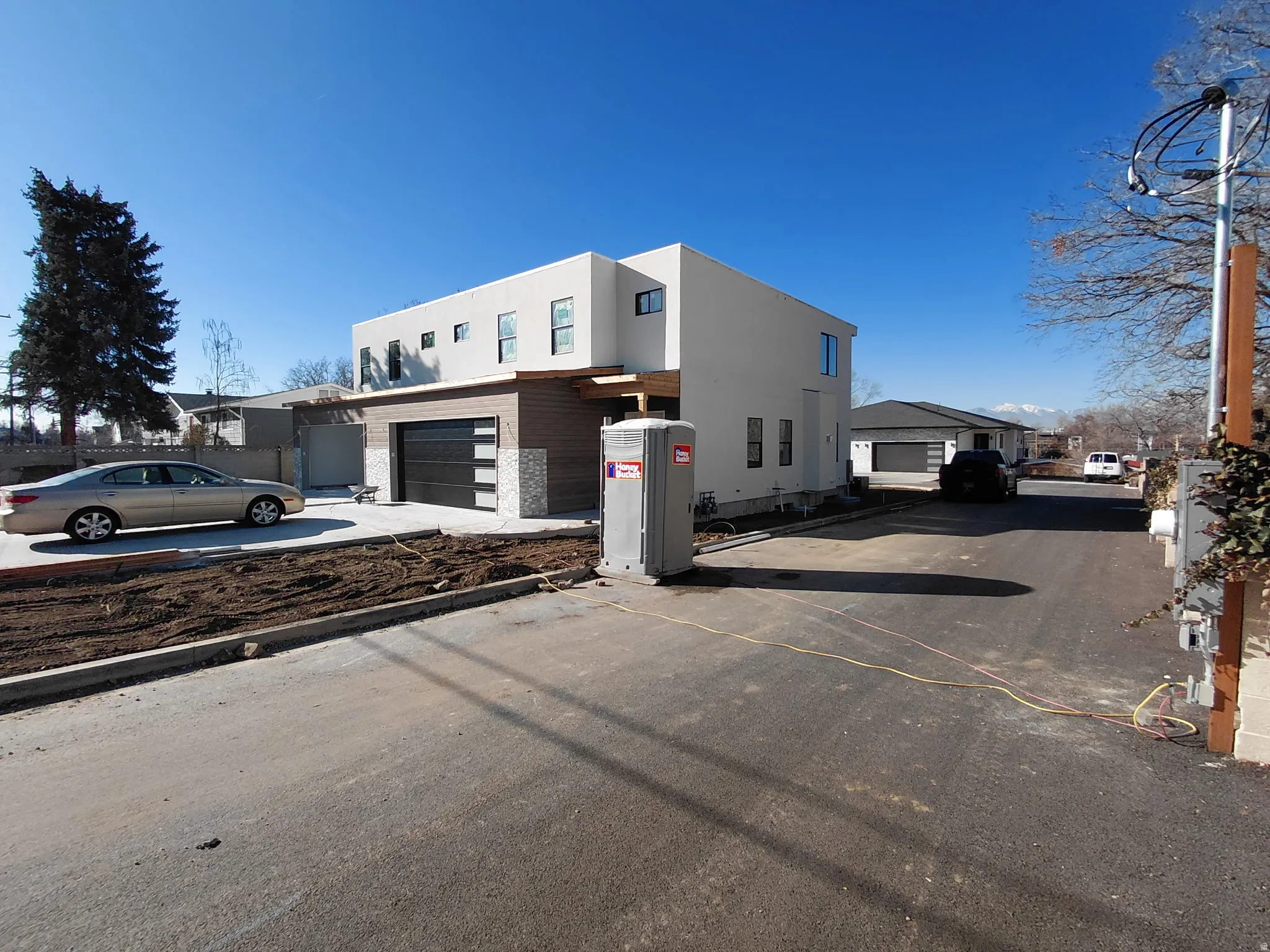 View of side of home with an attached garage, driveway, and stucco siding