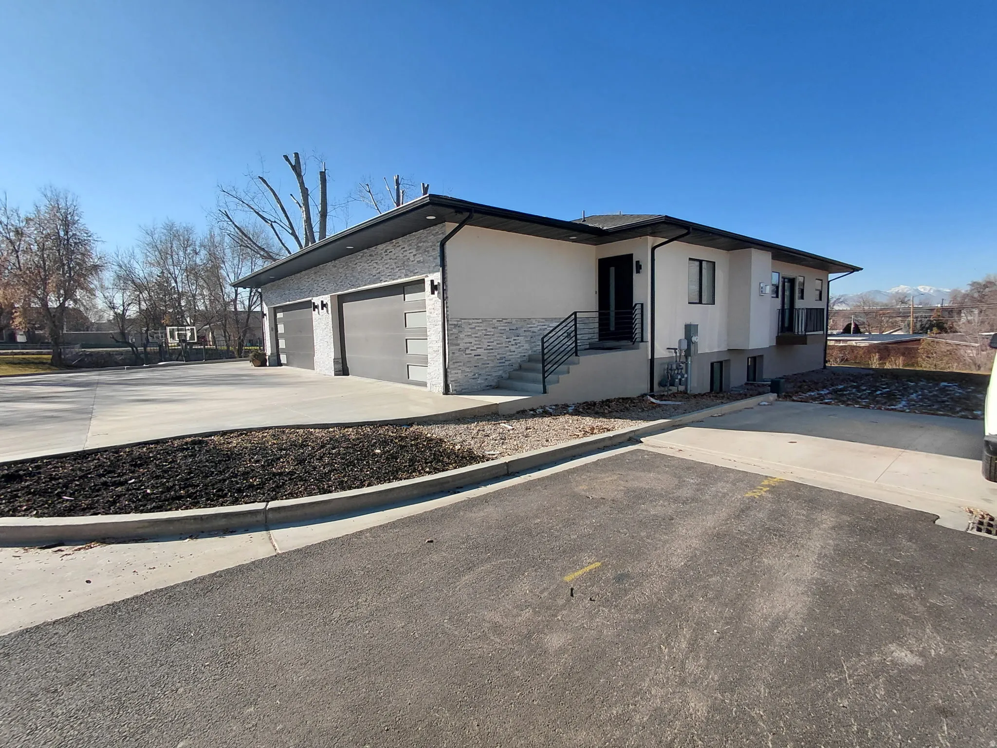 View of front of home with a garage, concrete driveway, and stucco siding