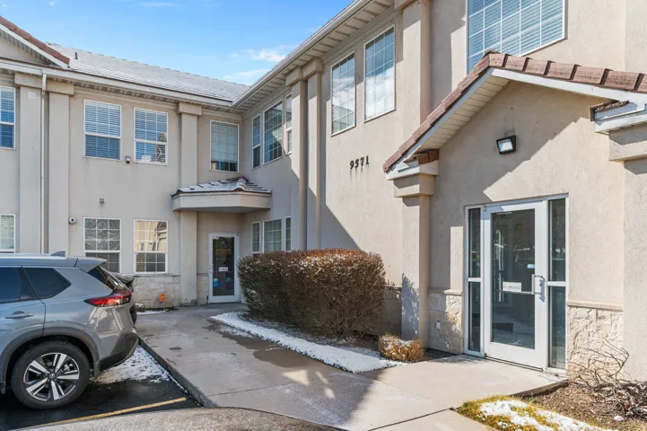 Doorway to property featuring stone siding and stucco siding