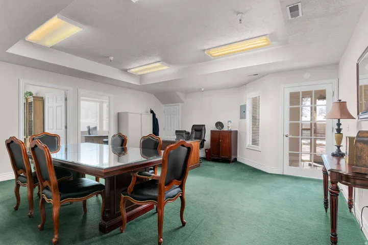 Carpeted dining space featuring a tray ceiling, a textured ceiling, and electric panel