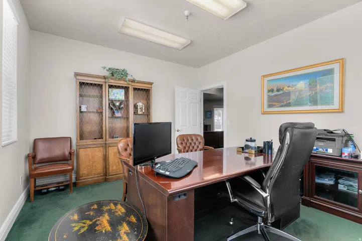 Carpeted office space with baseboards
