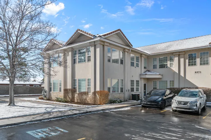 View of apartment building / complex with uncovered parking