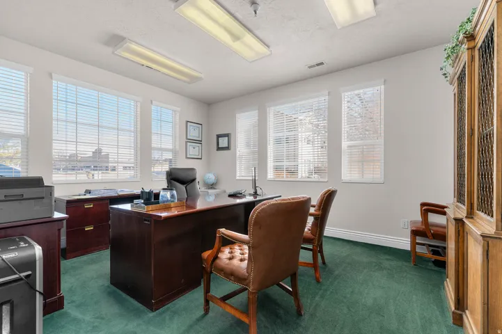 Office featuring dark colored carpet and a textured ceiling