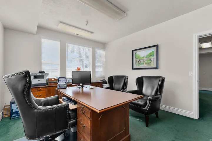 Office space featuring dark colored carpet and a textured ceiling