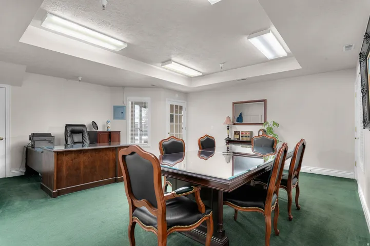 Dining space featuring carpet, an office area, a tray ceiling, a textured ceiling, and electric panel