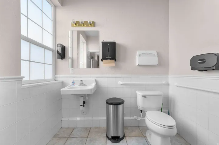 Bathroom with wainscoting, tile walls, and tile patterned flooring