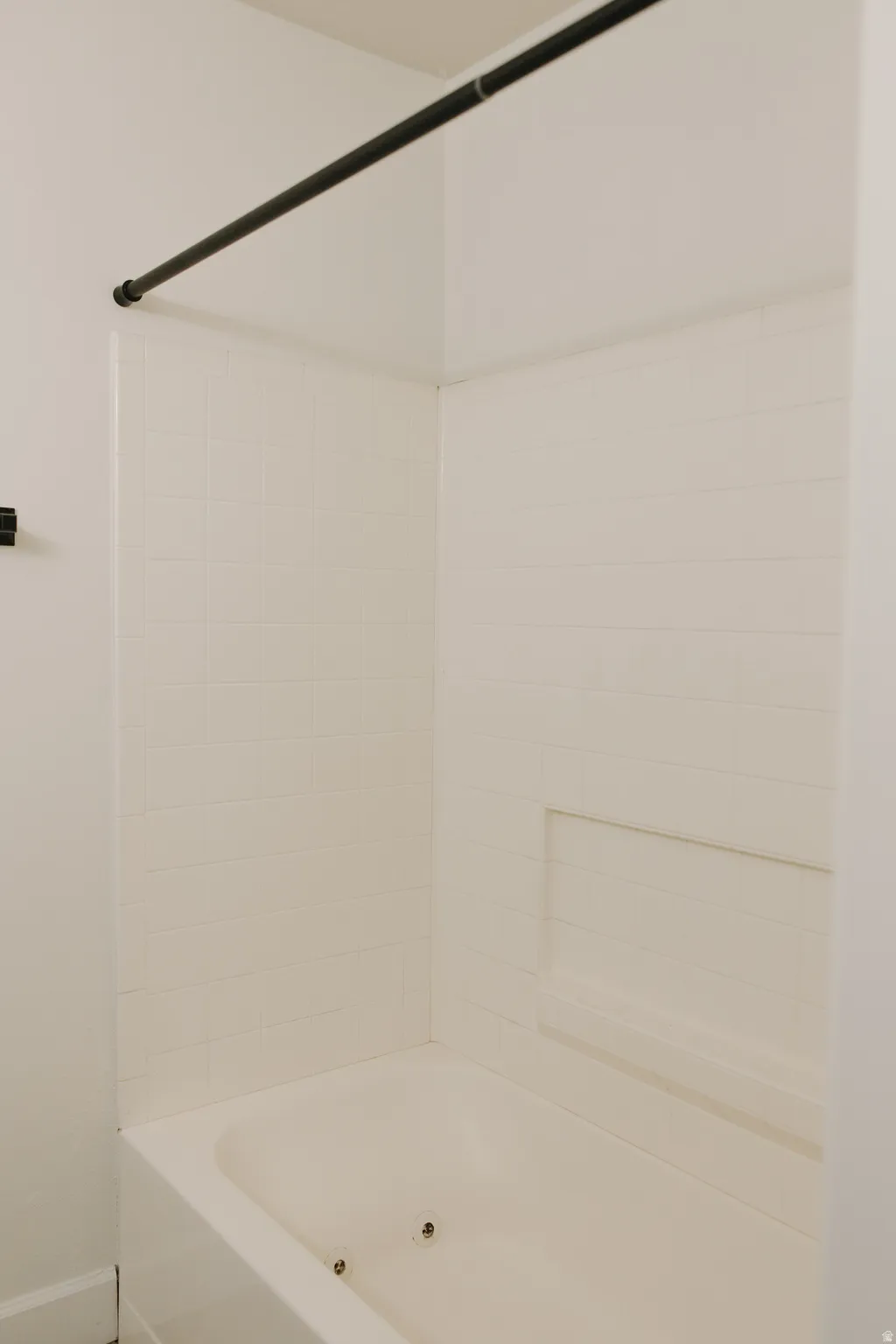 Bathroom with bathtub / shower combination and baseboards