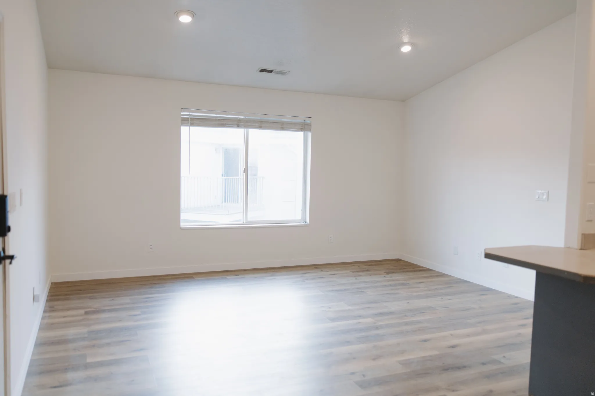 Empty room featuring light wood-type flooring and recessed lighting