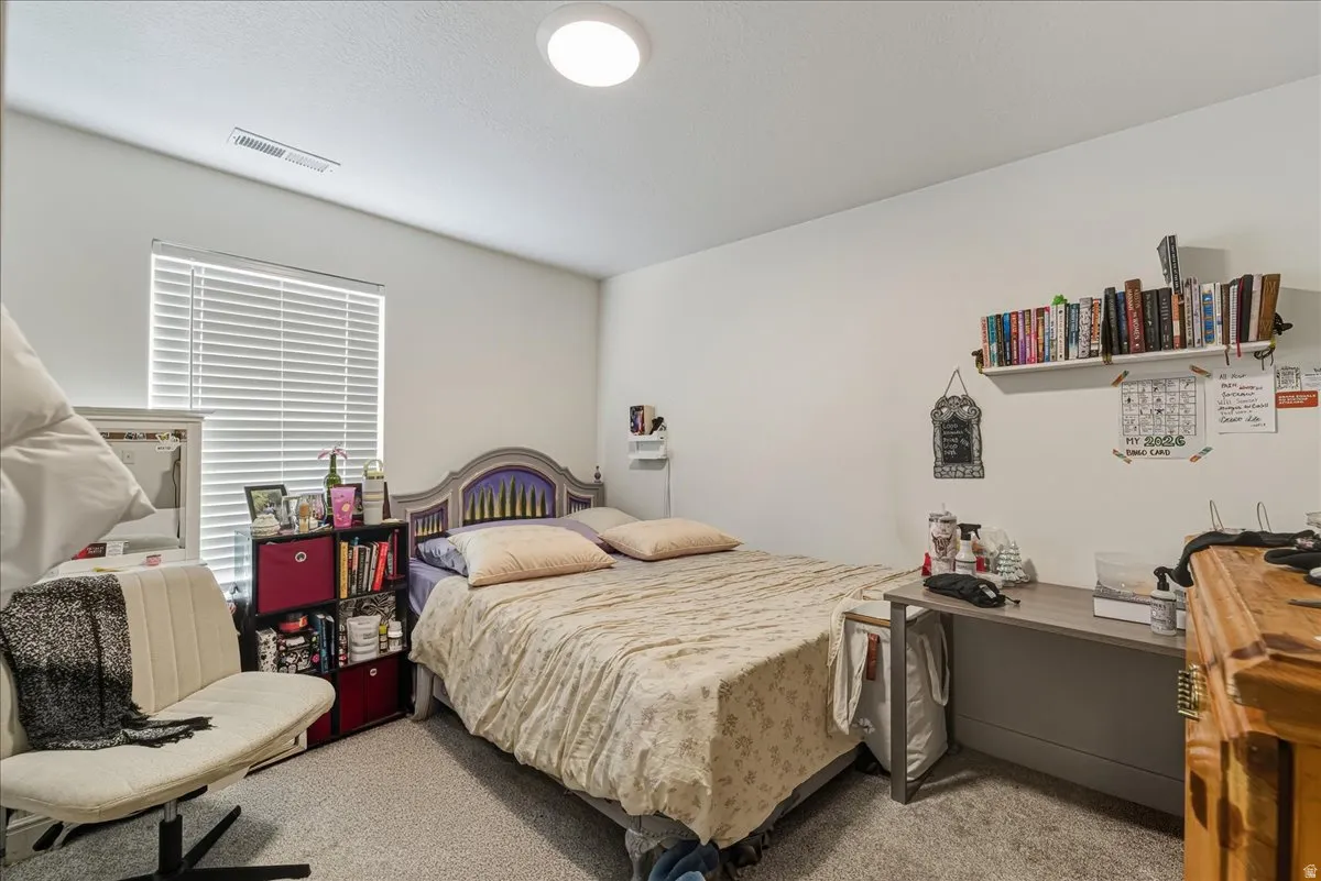 Bedroom featuring light carpet