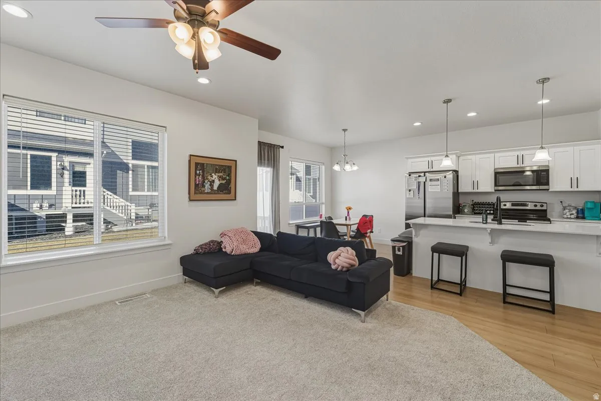 Living room with a ceiling fan and a chandelier