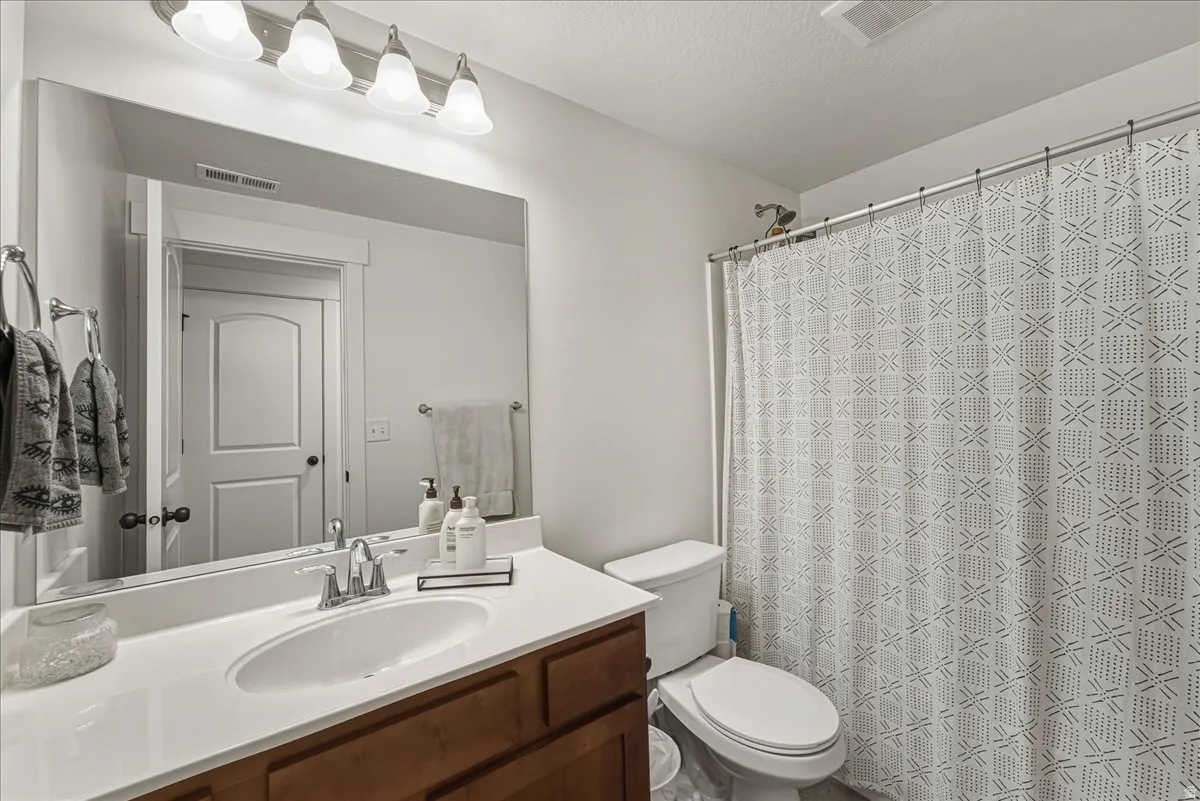 Full bath with vanity and a shower with shower curtain