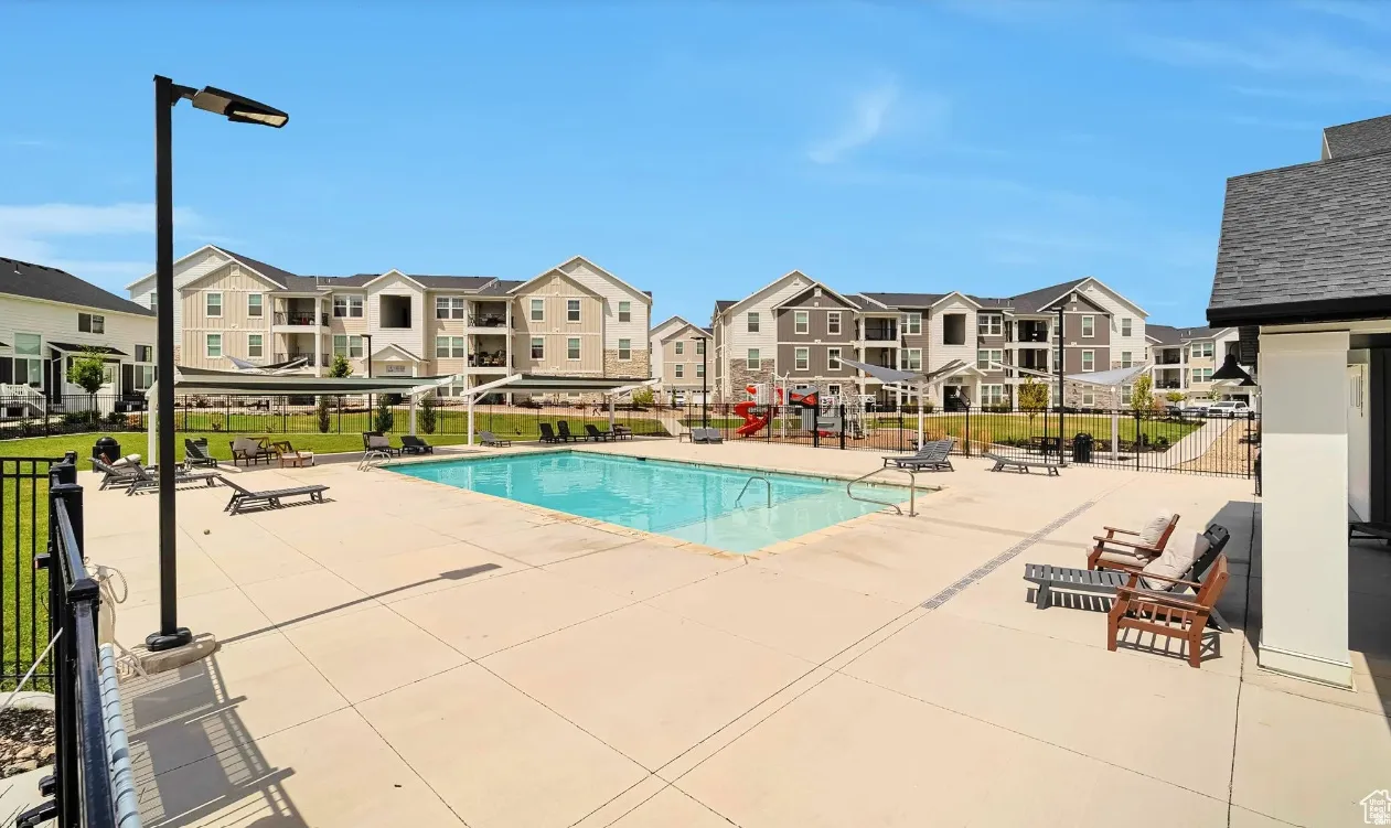 Community pool featuring a patio area and a residential view
