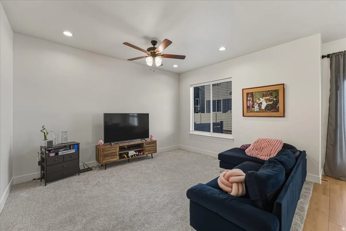 Living room with ceiling fan and recessed lighting