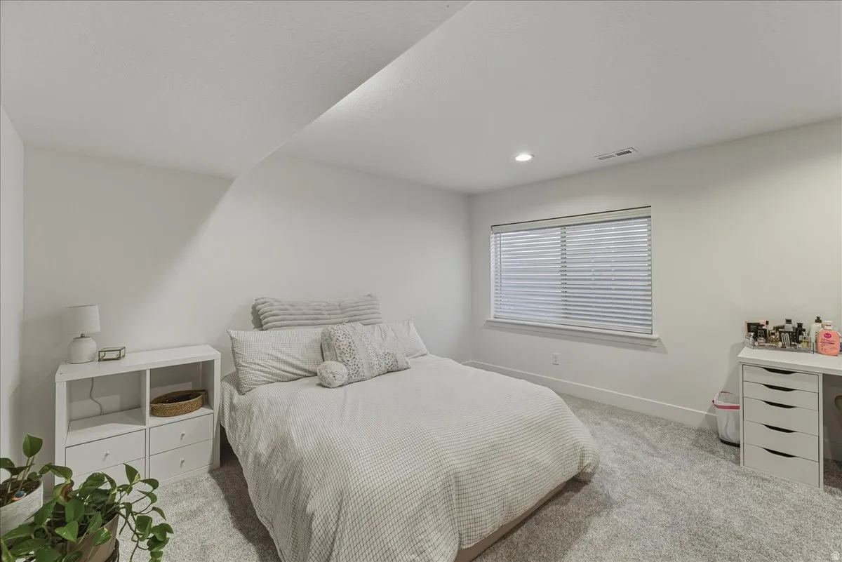 Bedroom with light colored carpet and recessed lighting