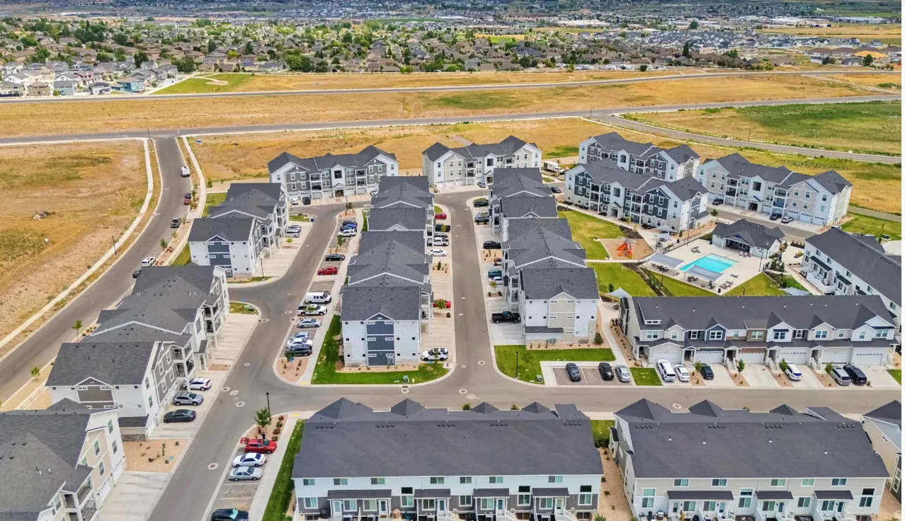 Aerial view of property and surrounding area featuring nearby suburban area