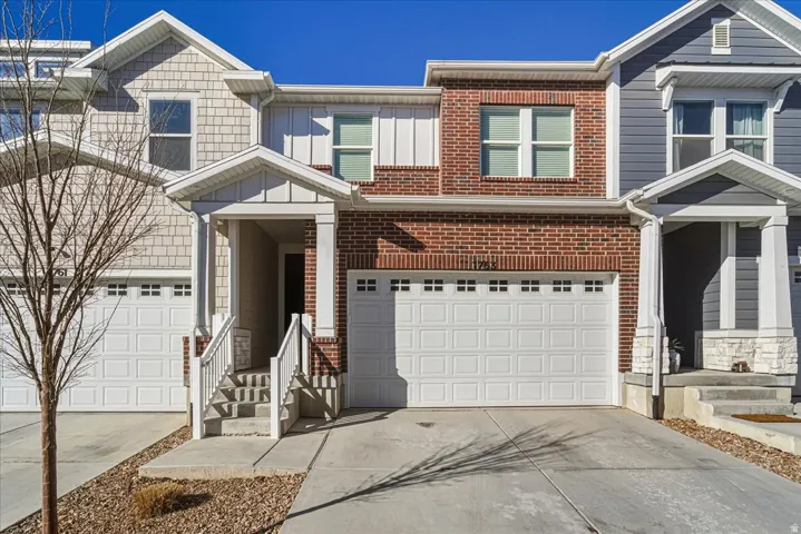 Traditional-style house featuring driveway, a garage, and brick siding