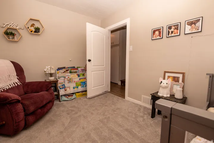 Living area featuring light colored carpet and baseboards