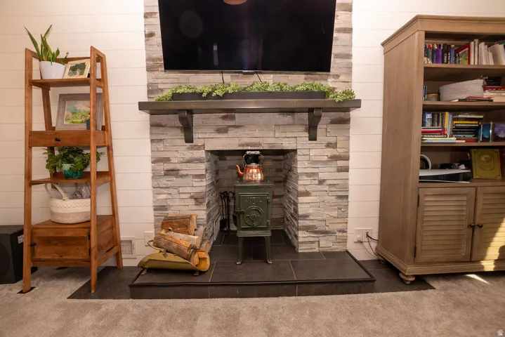 Detailed view of carpet, a wood stove, and wooden walls