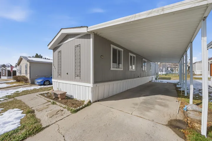 View of side of home with a carport and concrete driveway