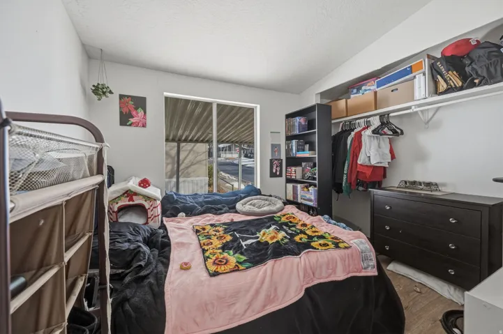 Bedroom with a closet, wood finished floors, and a textured ceiling