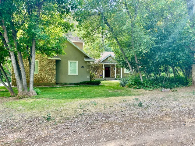 View of front of home featuring stucco siding, stone siding, and a front yard