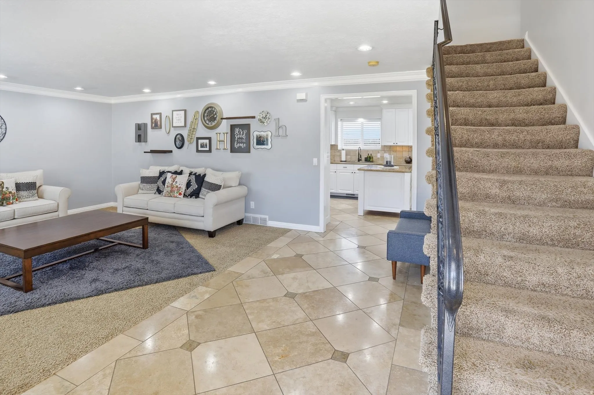 Living area featuring light tile patterned floors, light colored carpet, recessed lighting, and crown molding