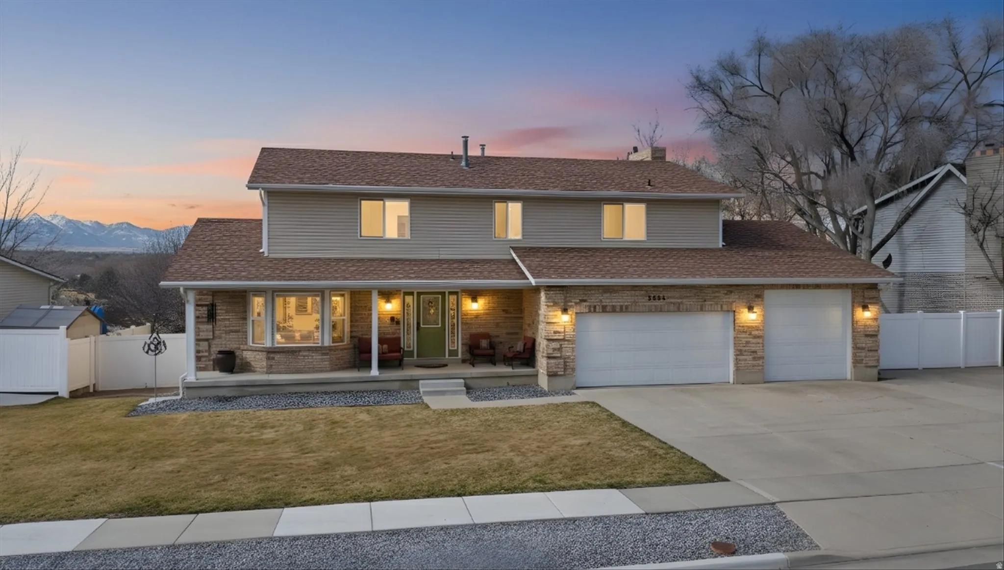 Traditional-style house with covered porch, concrete driveway, an attached garage, a chimney, and brick siding