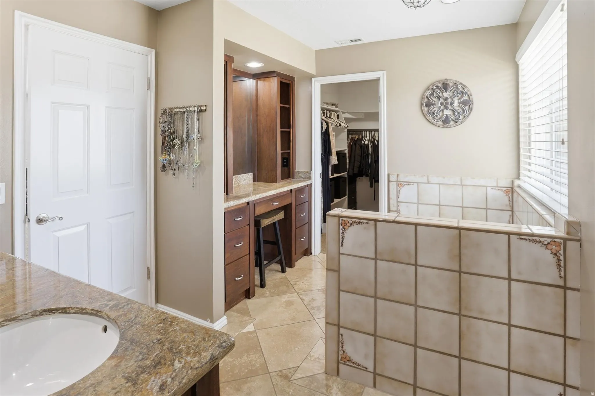 Bathroom featuring a spacious closet, vanity, light tile patterned flooring, and recessed lighting