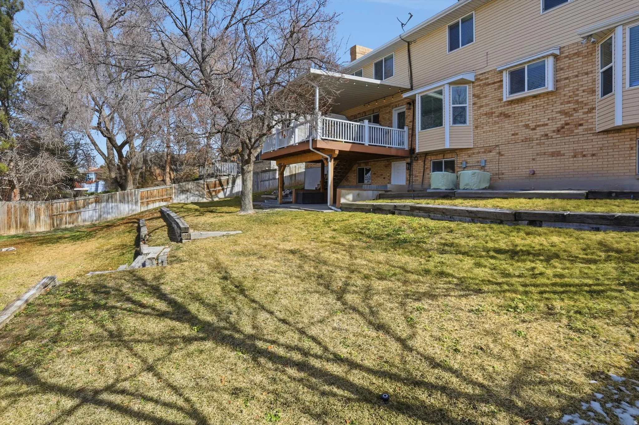Back of house featuring a patio area, brick siding, and a wooden deck